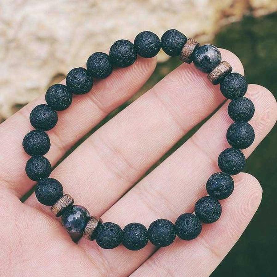 Gros plan sur les perles de lave et bois du bracelet