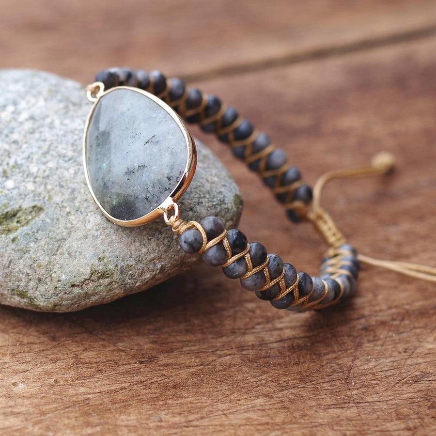 Bracelet en labradorite posé sur une surface en bois
