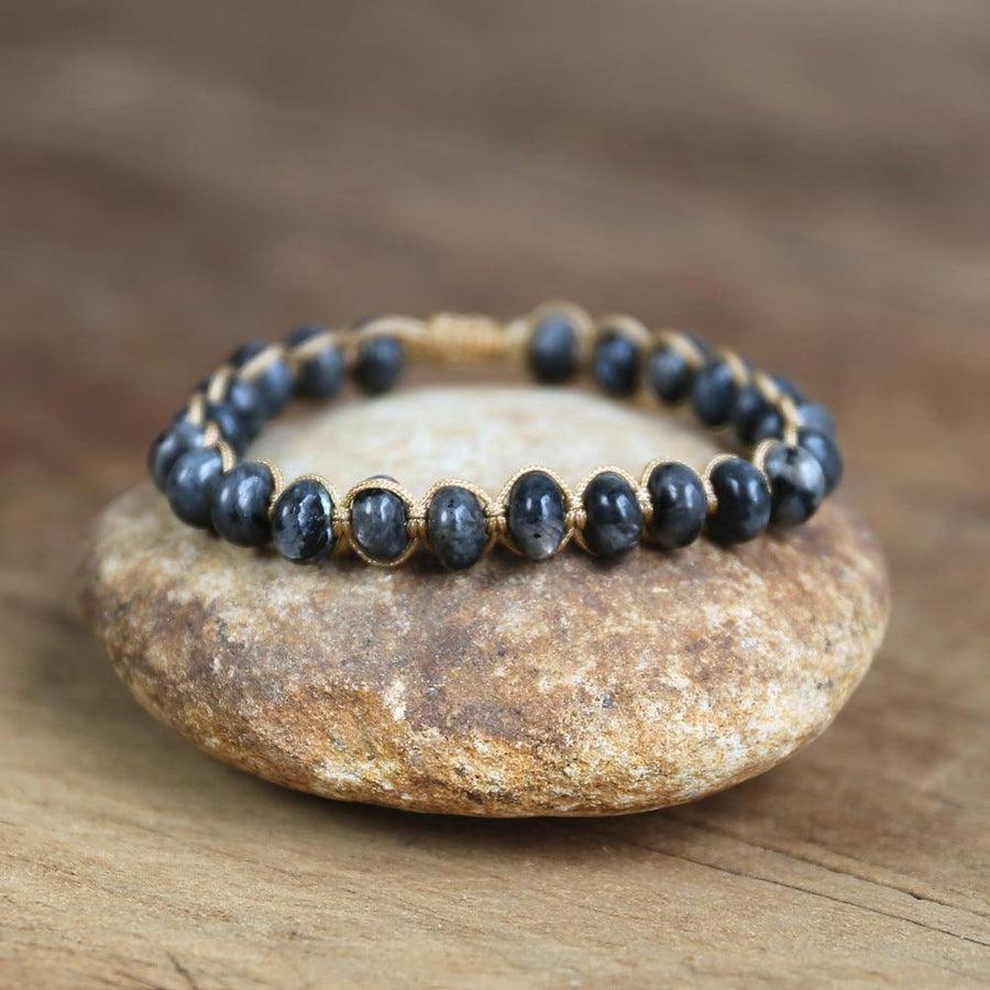 Bracelet en labradorite posé sur une surface en bois