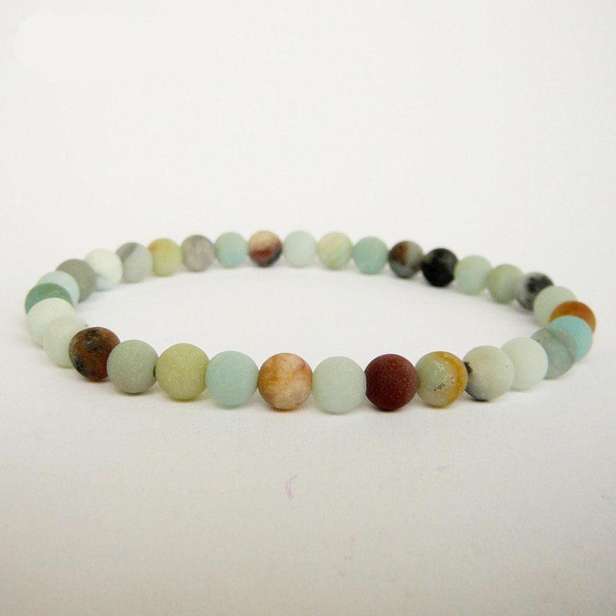 Bracelet en amazonite posé sur une surface en bois clair