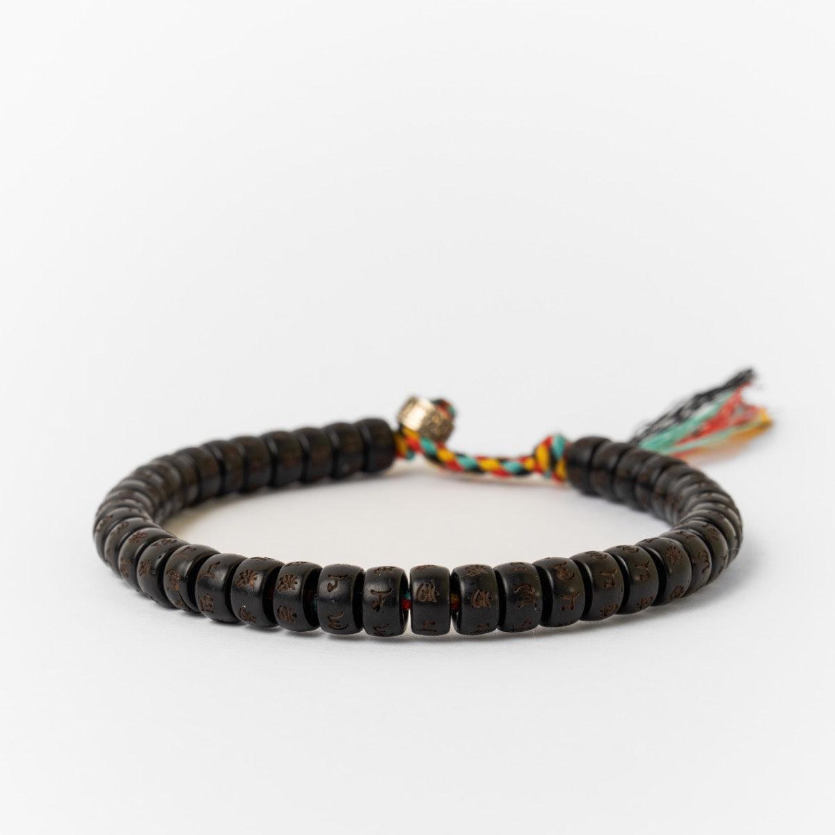 Vue rapprochée des perles gravées sur le bracelet coloré