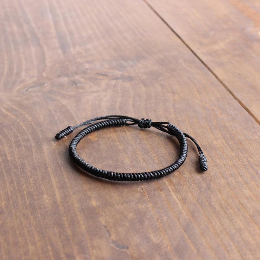 Vue rapprochée du tressage manuel du bracelet noir