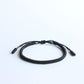 Détail des mantras tressés sur le bracelet noir