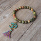 Bracelet tibétain en Unakite posé sur une surface claire