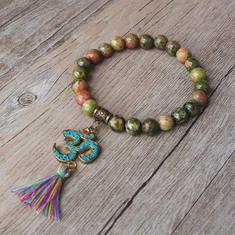 Bracelet tibétain en Unakite posé sur une surface claire