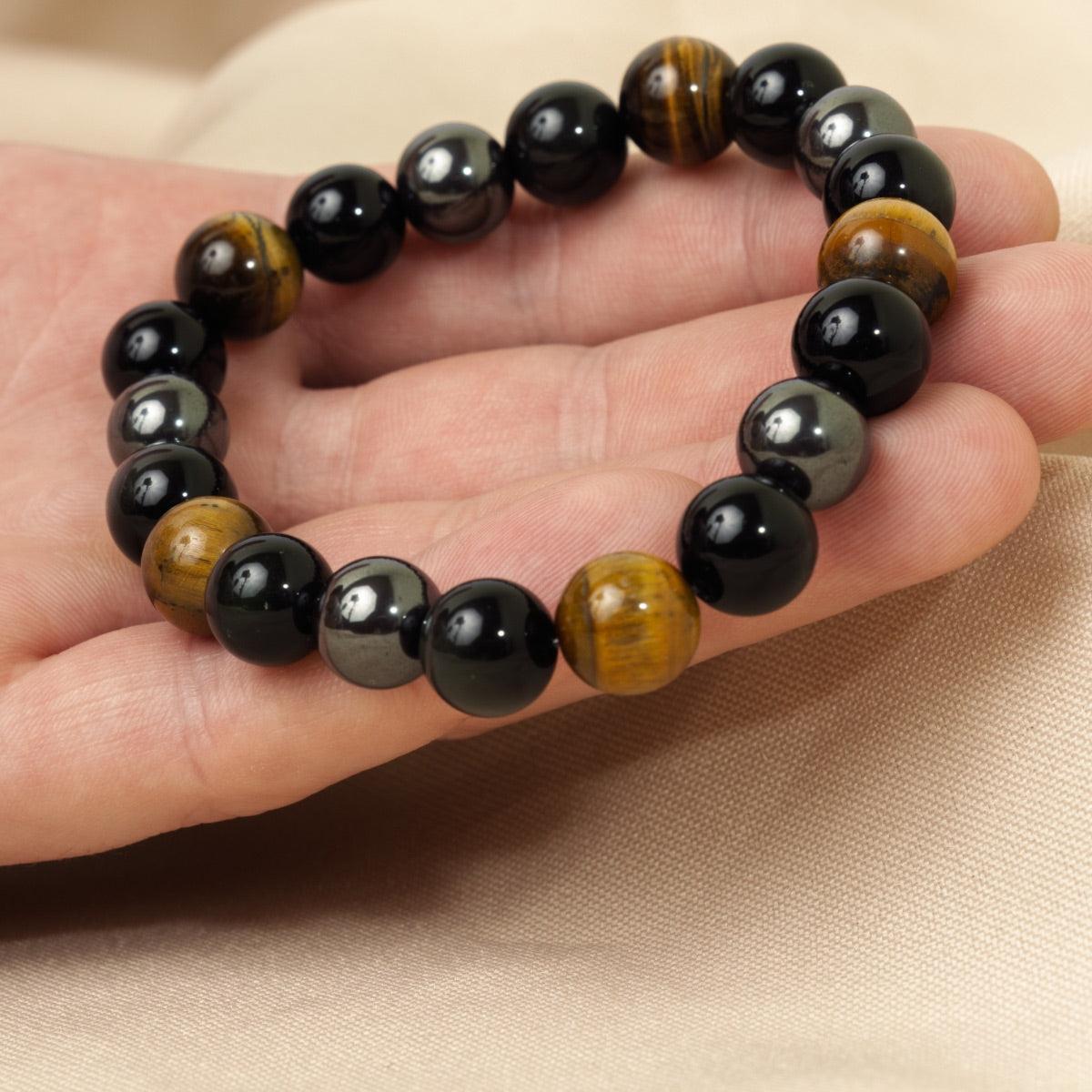 Bracelet triple protection posé sur une surface claire