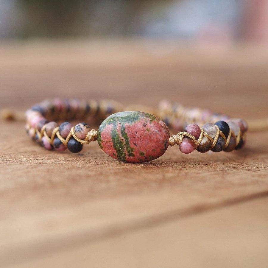 Bracelet en jaspe et rhodonite posé sur une surface en bois