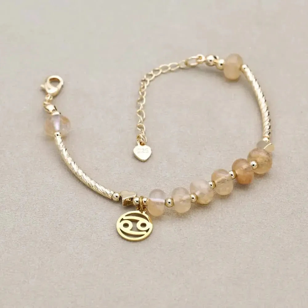 Gros plan sur les perles dorées et le quartz fumé du bracelet