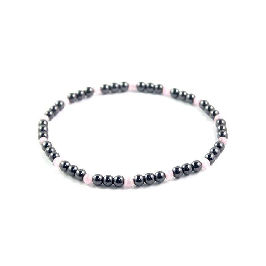 Détail des perles brunes et blanches sur bracelet de cheville