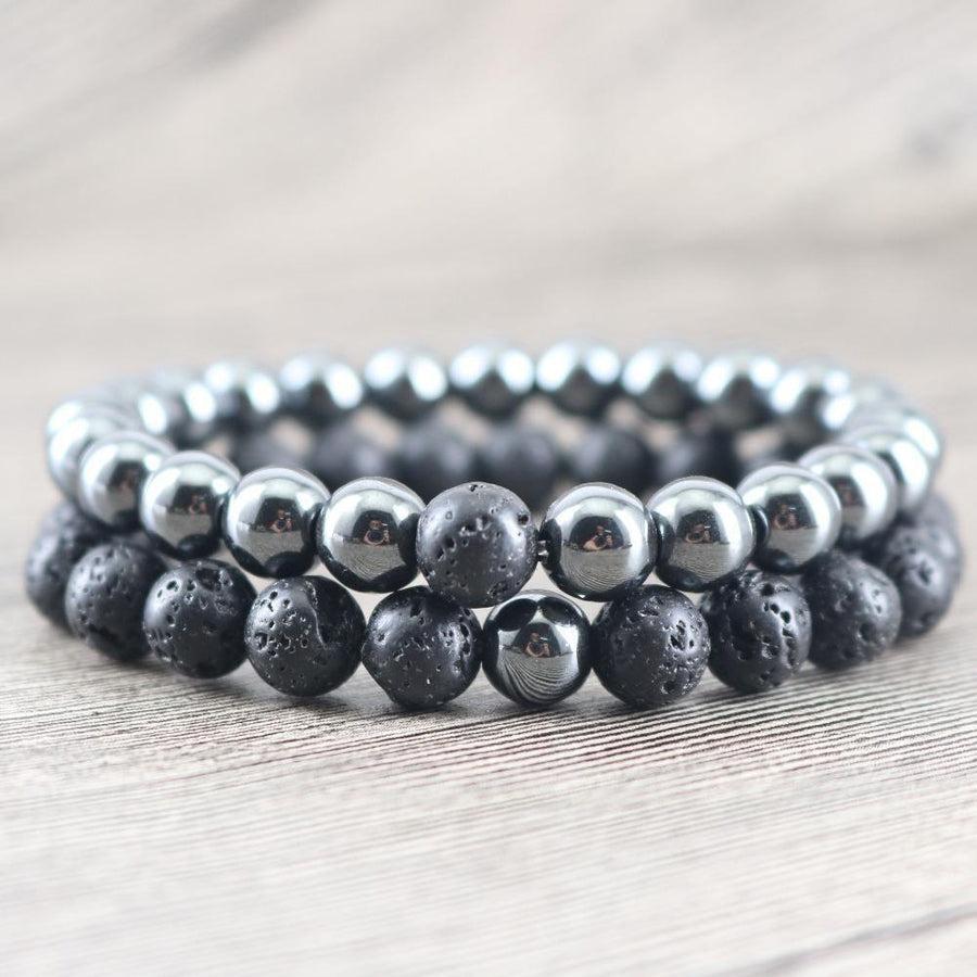 Deux bracelets en hématite et pierre de lave sur fond neutre