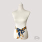 Vue rapprochée d'une ceinture foulard aux motifs artistiques colorés