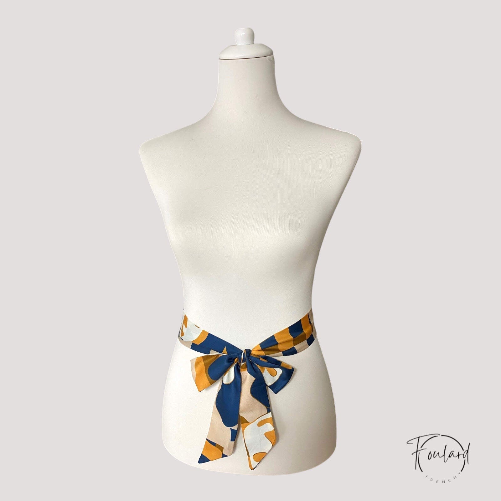 Vue rapprochée d'une ceinture foulard aux motifs artistiques colorés