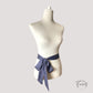 Gros plan sur la texture fluide de la ceinture foulard grise