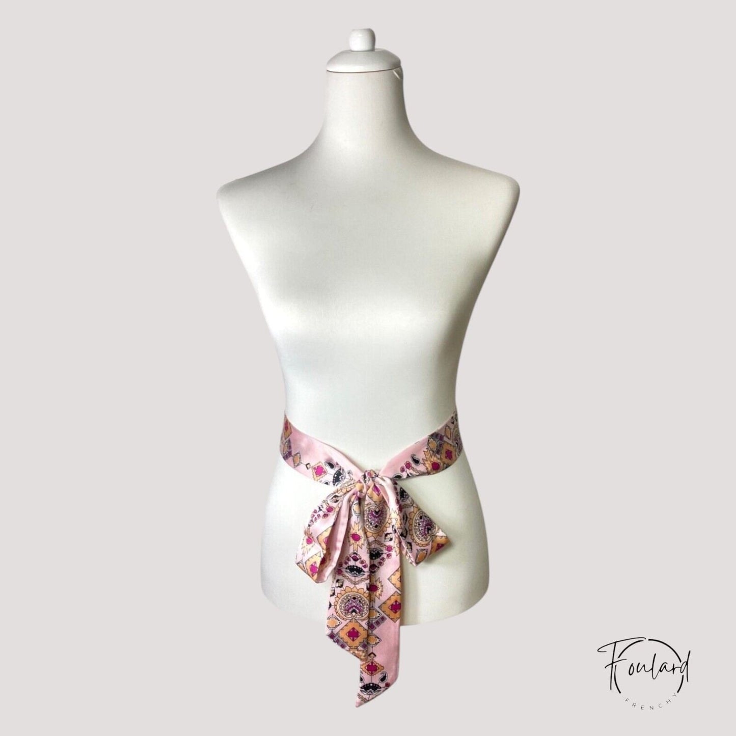 Détail du tissu satiné rose avec motifs aztèques colorés