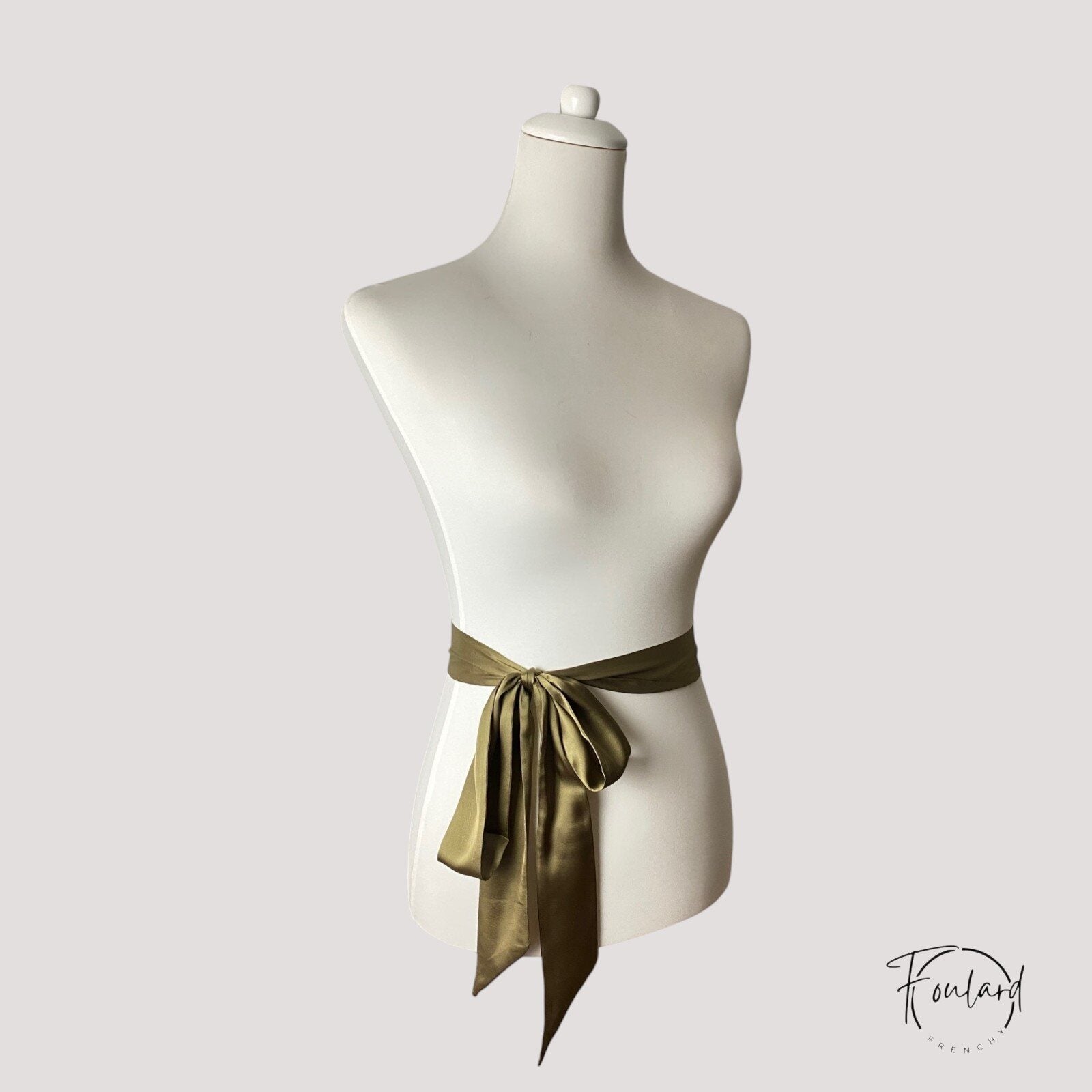 Gros plan sur texture satinée de la ceinture vert olive