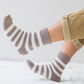 Chaussettes grises et blanches sur fond blanc, vue de côté