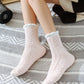 Chaussettes rose pastel et blanches sur fond neutre