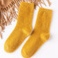 Chaussettes jaunes en moumoute pliées sur une surface