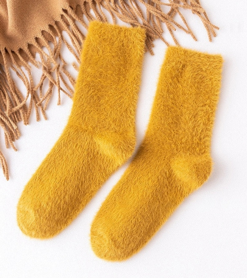 Chaussettes jaunes en moumoute pliées sur une surface