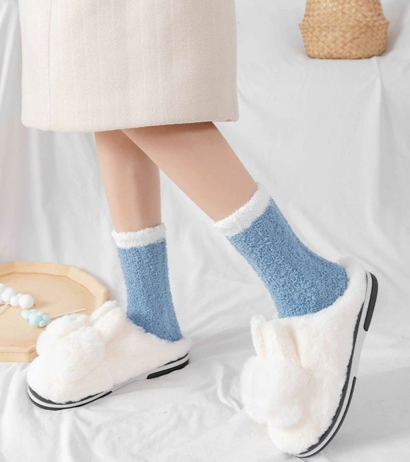 Chaussettes en laine synthétique bleue posées sur une surface claire