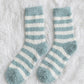 Gros plan sur chaussettes marinières turquoise et blanches