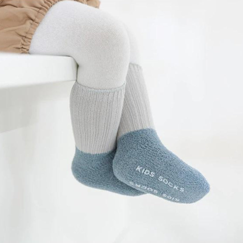 Chaussettes polaires bicolores rose et beige posées sur une table