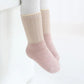 Vue de côté des chaussettes grises et bleues avec détails antidérapants