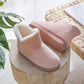 Chaussons rose pastel sur fond blanc, vue de côté