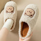 Gros plan sur le motif ourson brodé des chaussons en peluche