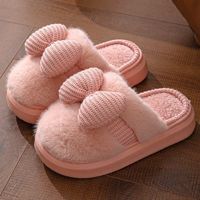 Gros plan sur le pompon rose des chaussons moelleux