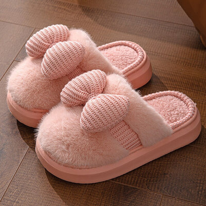 Gros plan sur le pompon rose des chaussons moelleux