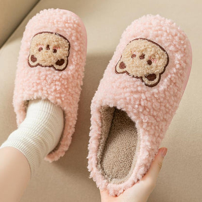 Vue de côté des chaussons en peluche rose avec ourson