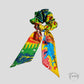 Chouchou foulard multicolore posé sur un ours en peluche