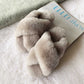 Claquettes en fausse fourrure noire sur fond blanc