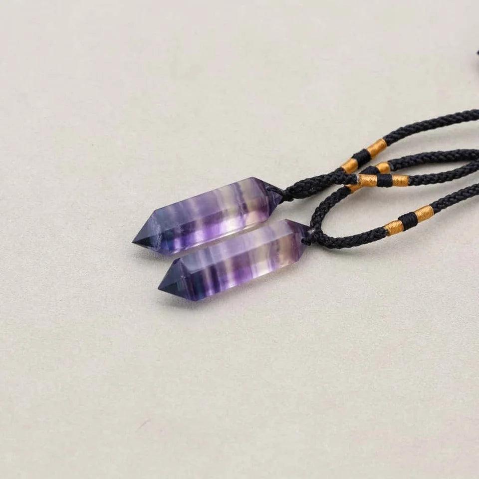 Gros plan sur un pendentif en fluorite mauve naturelle
