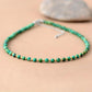Collier de perles sur fond neutre, chaînette visible