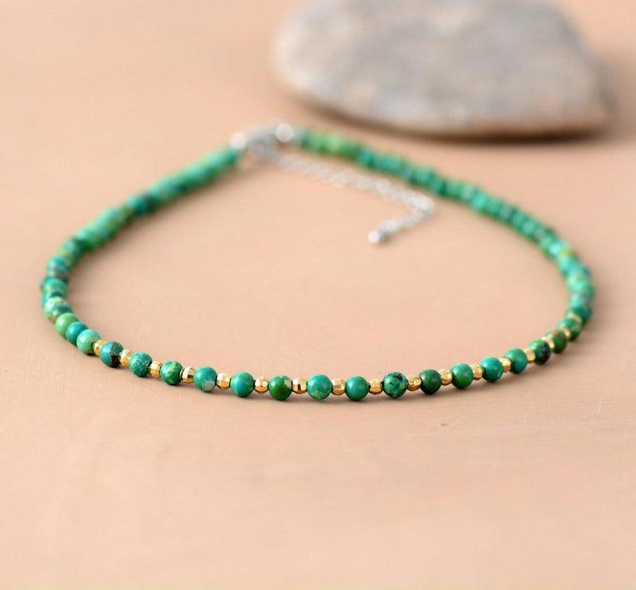 Collier de perles sur fond neutre, chaînette visible