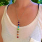 Collier des 7 chakras posé sur une surface claire