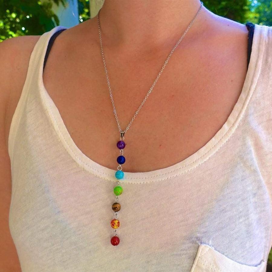 Collier des 7 chakras posé sur une surface claire