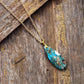 Collier avec pendentif turquoise sur tissu beige