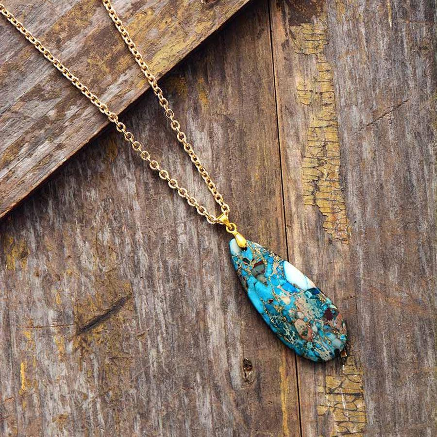 Collier avec pendentif turquoise sur tissu beige