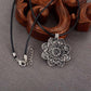 Vue rapprochée du pendentif tibétain avec motifs spirituels