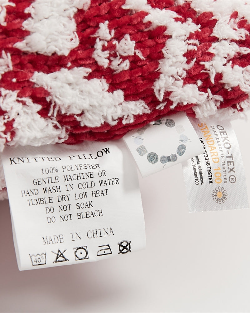 Détail des coutures renforcées du coussin rouge et blanc