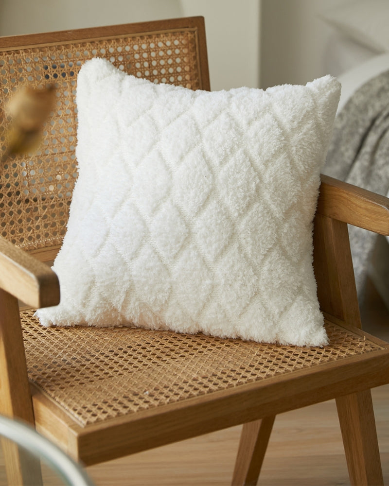 Coussin en duvet blanc posé sur un lit, style classique