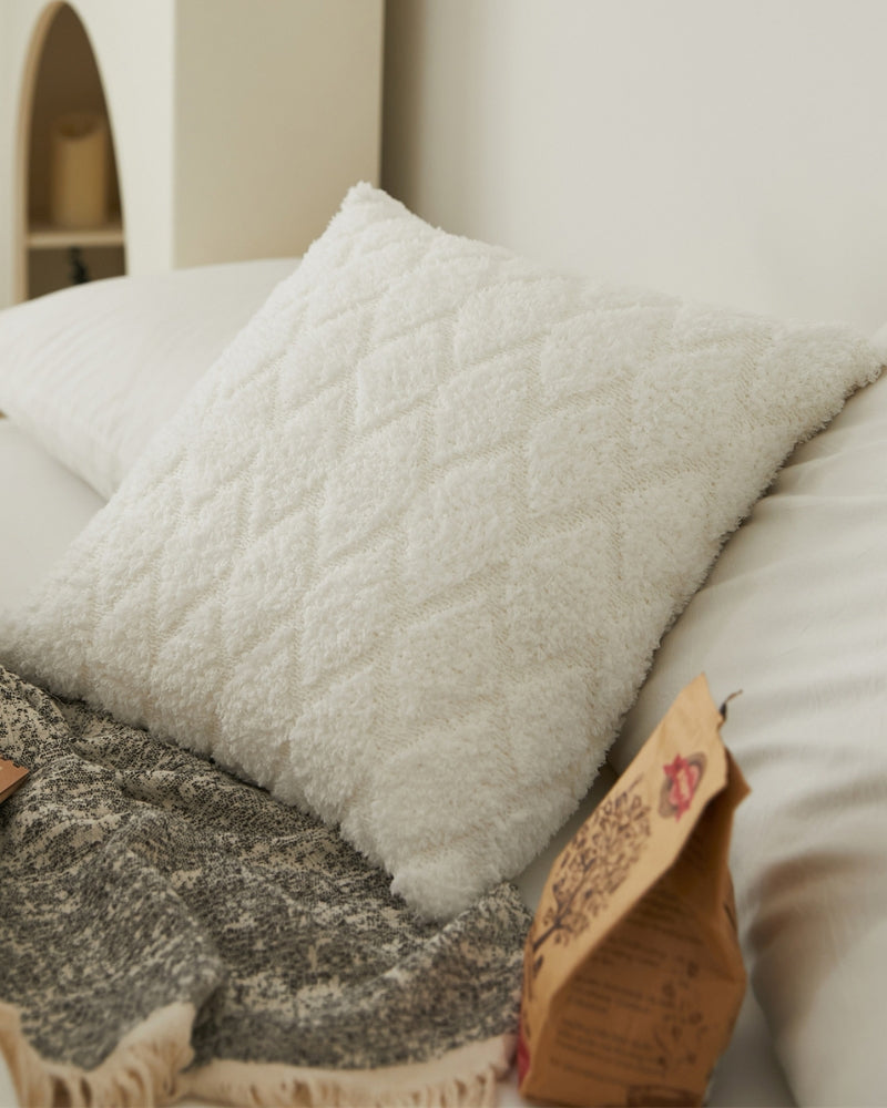 Gros plan sur la texture duveteuse du coussin blanc