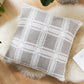 Coussin gris à carreaux en fourrure sur fond blanc