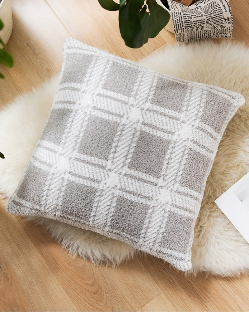 Coussin gris à carreaux en fourrure sur fond blanc