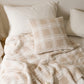 Coussin beige à carreaux sur fond blanc