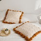 Vue rapprochée des pompons doux entourant le coussin