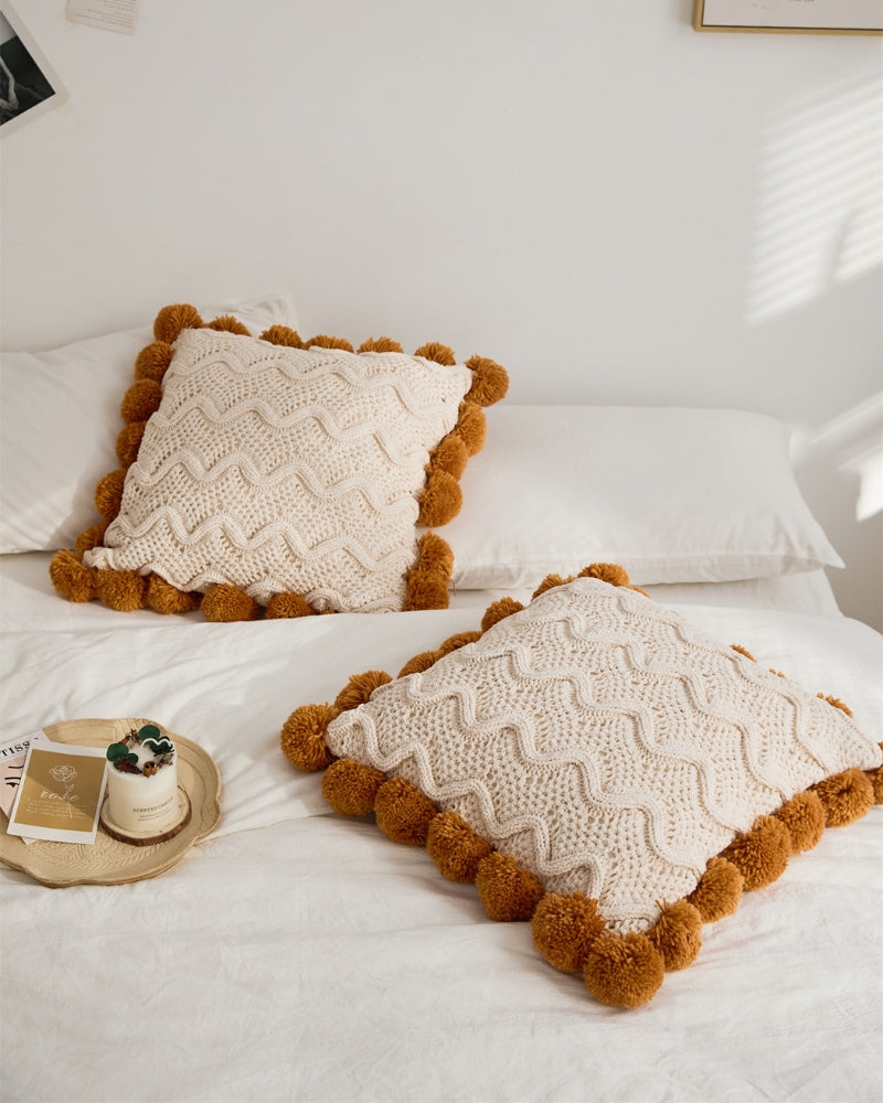 Vue rapprochée des pompons doux entourant le coussin